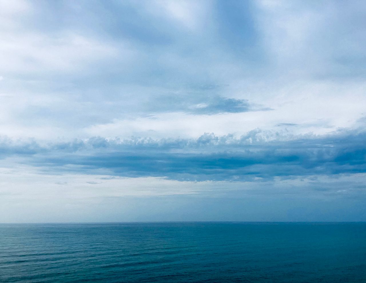 A tranquil ocean scene with a vast sky, evoking calm and serenity.